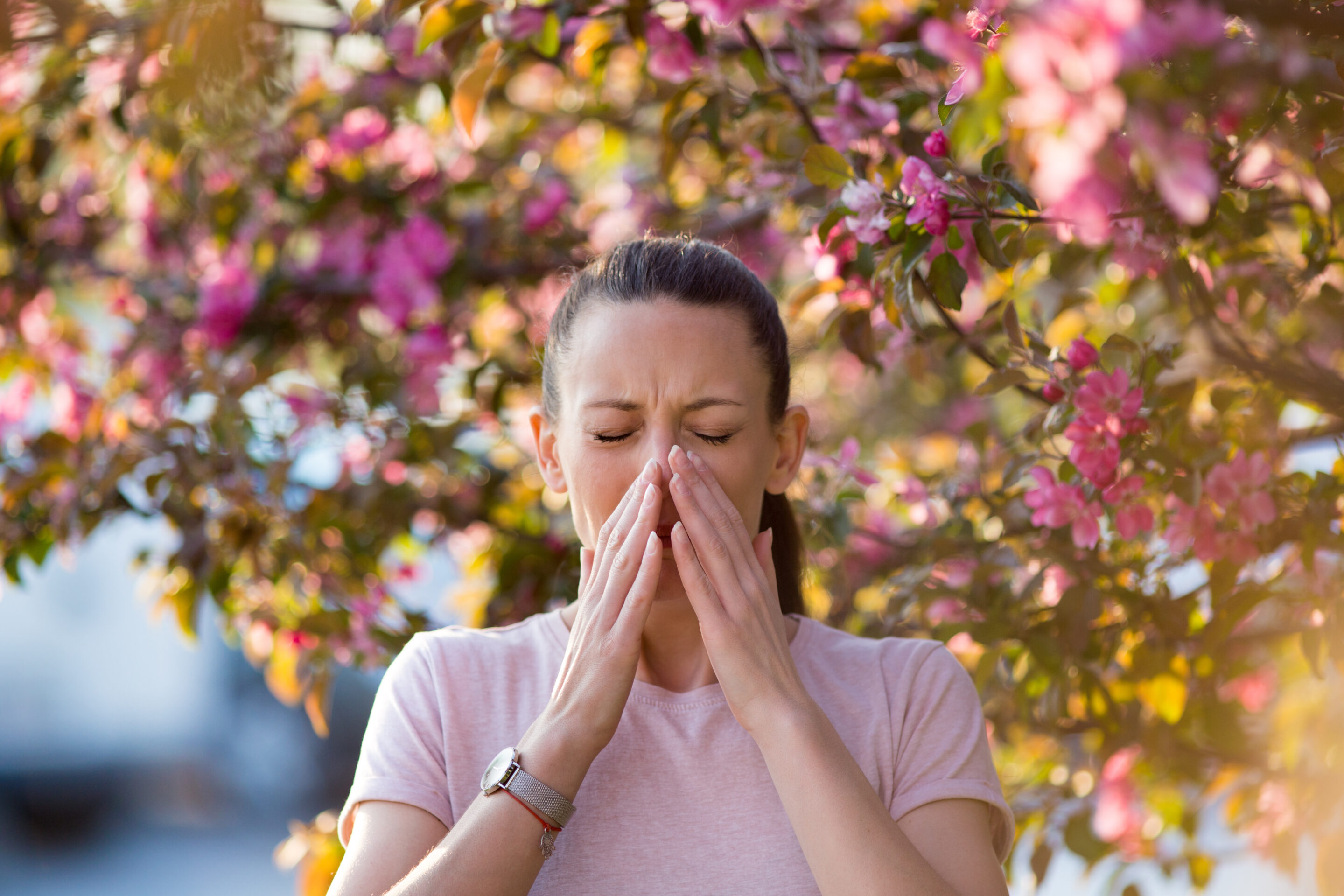 Niesende Frau bei einer Pollenallergie